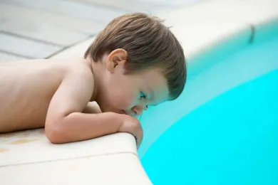 Kind am Beckenrand eines Pools
