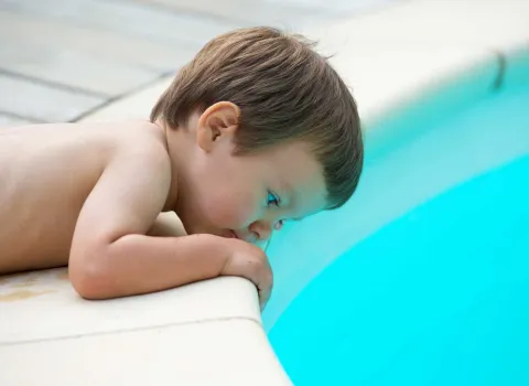 Kind am Beckenrand eines Pools